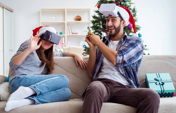 Happy family using virtual reality VR glasses during christmas - Foto, imagen