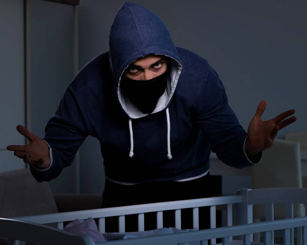 人身売買の概念で赤ん坊を盗む犯罪者 - 写真・画像