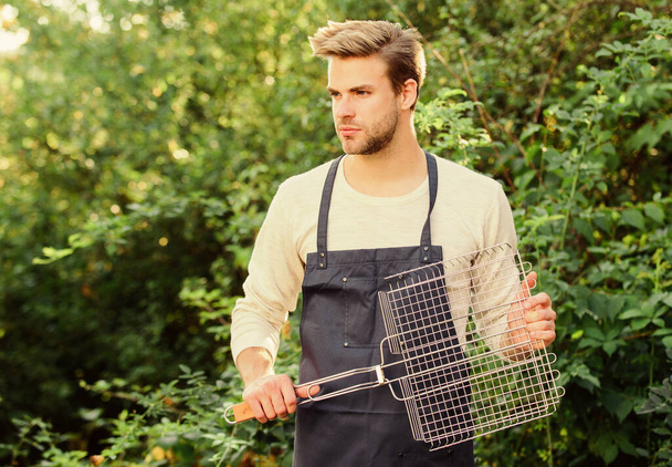 Picnic concept. Man hold grilling grid. Grilling food. Backyard barbeque party. Handsome guy cooking food. Healthy meal. Recipe grill. Different methods grilling beef chicken vegetables and seafood - Fotografie, Obrázek