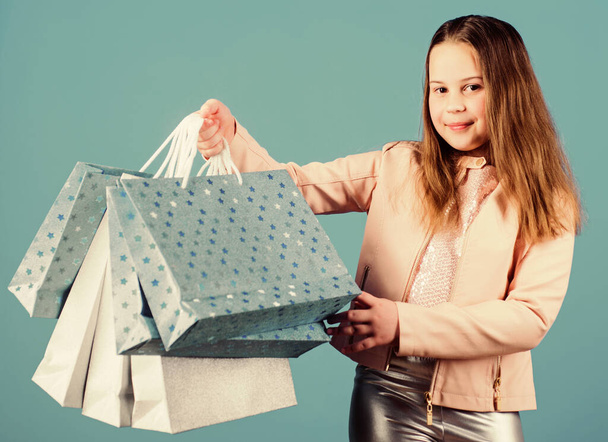 Holiday purchase saving. Sales and discounts. Kid fashion. shop assistant with package. Small girl with shopping bags. Happy child. Little girl with gifts. christmas shopping. shristmas gifts - 写真・画像