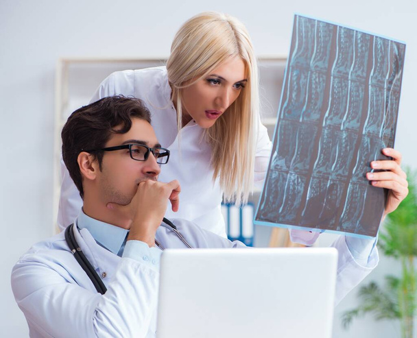 診断のために患者のX線画像を調べる二人の医師 - 写真・画像
