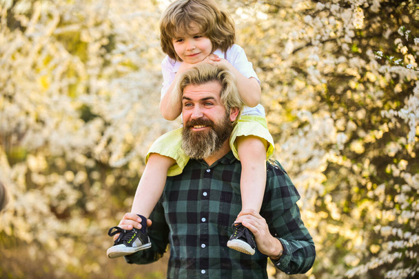 Earth day. Little boy and father in nature background. Hipster and baby son. Happiness concept. Spring walk. Ecology and environment. Simple happiness. Happy family. Fatherhood happiness. Fathers day - Foto, imagen