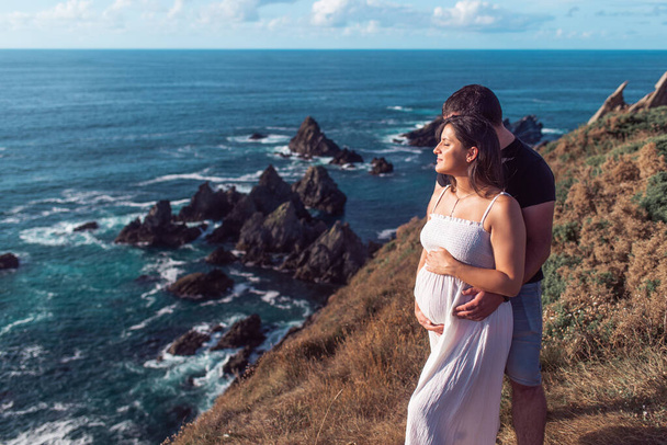 Pregnant couple on top of the Loiba Cliffs in Galicia, Spain - Foto, afbeelding