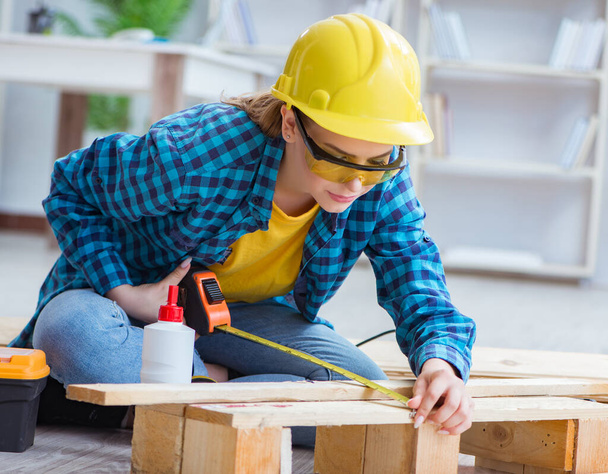 Female repairman carpenter cutting joining wooden planks doing r - Photo, Image