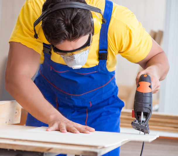 Young repairman carpenter working with a circular saw - Foto, Imagem