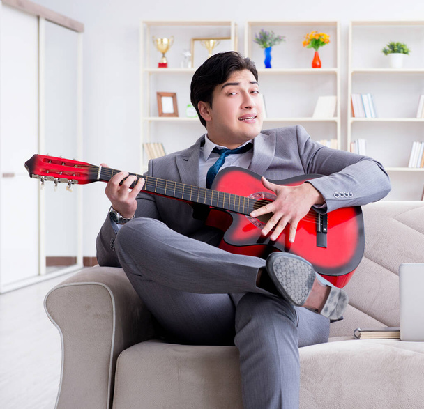 Biznesmen gra na gitarze w domu - Zdjęcie, obraz
