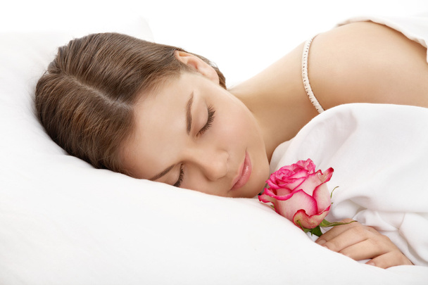 The sleeping girl with a flower - Foto, afbeelding