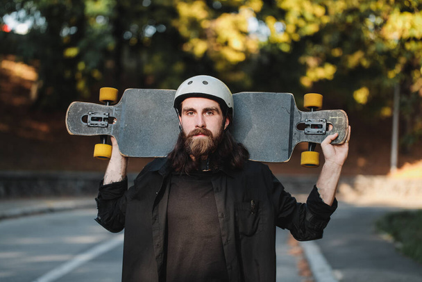 Lifestyle style of sketching, longboard. Portrait of a bearded guy with a board. - 写真・画像