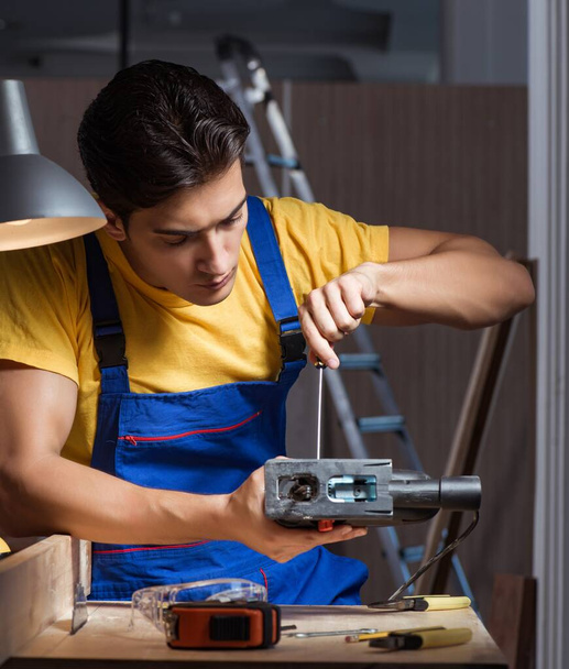 Trabajador que trabaja en taller de reparación en concepto de carpintería - Foto, imagen