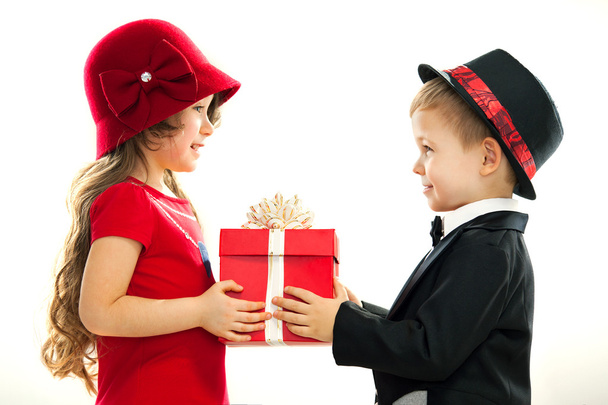 Маленький хлопчик дарує дівчинці подарунок
 - Фото, зображення