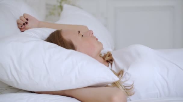 Beautiful woman with insomnia cant sleep at night. She tosses and turns in bed. - Metraje, vídeo