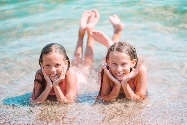 Schattige kleine meisjes die plezier hebben op het strand - Foto, afbeelding