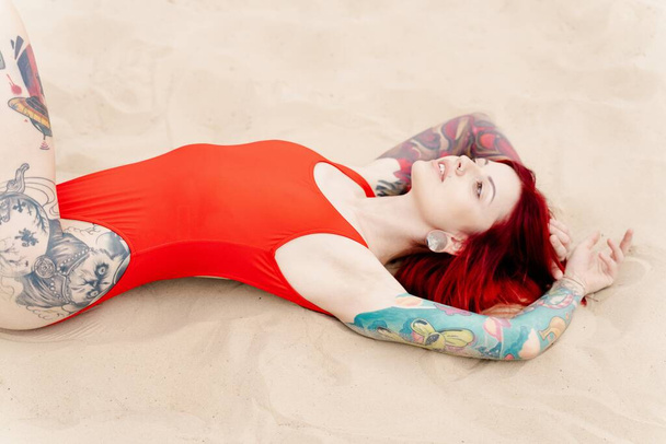 gorgeous young  tattooed woman in swimsuit on the beach  - Photo, Image