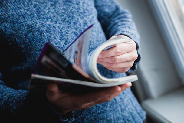 A man looks at a magazine. Press hands. - Фото, зображення