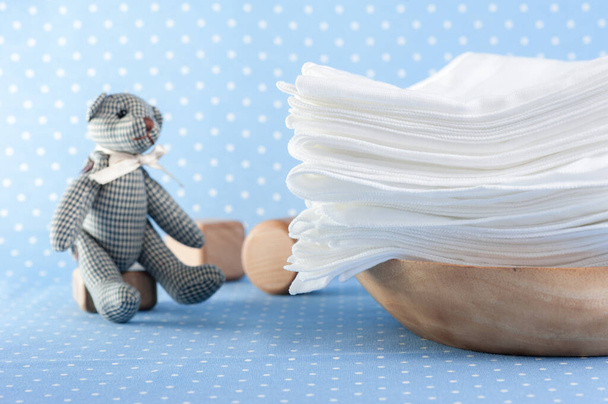 zbliżenie białe i miękkie pieluchy tkaniny dla niemowląt na niebieskim tle - Zdjęcie, obraz