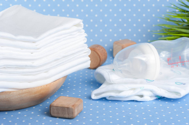 közelkép fehér és puha baba ruha pelenka felett kék háttér - Fotó, kép