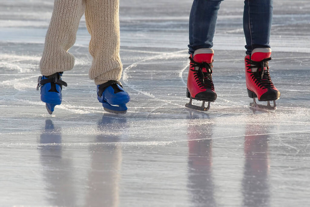 pies de diferentes personas patinando en la pista de hielo. pasatiempos y ocio. deportes de invierno - Foto, Imagen