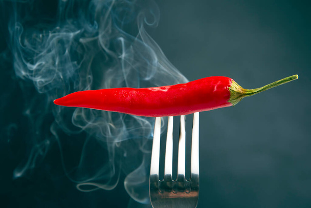red hot peppers on a fork in real smoke. vegetative vitamin foo - Photo, Image