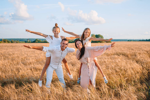 Famille heureuse jouant dans un champ de blé - Photo, image
