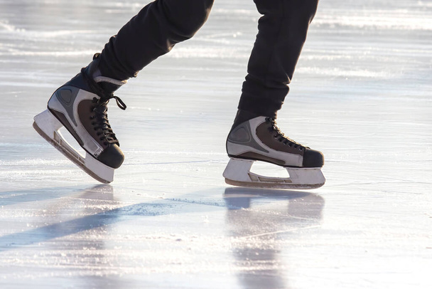 Patas de un patinador en patinaje sobre hielo en la pista de hielo de la calle. deporte de invierno. aficiones y recreación activa en los deportes. - Foto, Imagen