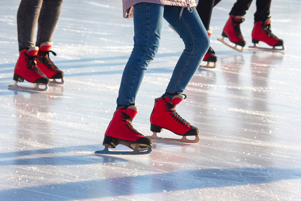 különböző emberek aktívan korcsolyáznak egy jégpályán. hobbik és szabadidő. téli sportok - Fotó, kép
