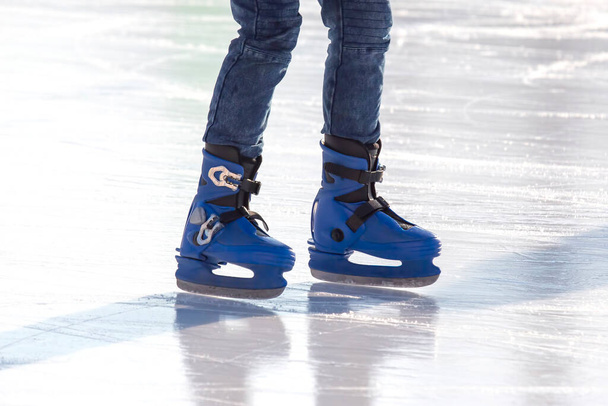ストリートアイスリンク上のアイススケートのスケーターの足。ウィンタースポーツ。趣味やスポーツでの積極的なレクリエーション. - 写真・画像