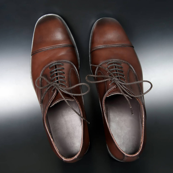Classic men's brown Oxford shoes on dark background - Fotó, kép