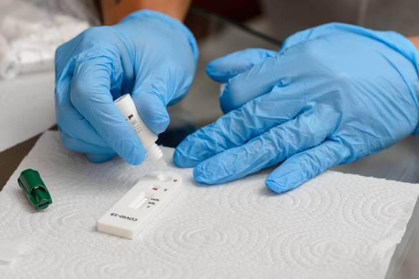 Lääkäri tekee testipakkauksen virustaudille COVID-19 nCoV. Laboratoriokorttitesti koronaviruksen varalta. COVID-19 pikatesti - Valokuva, kuva