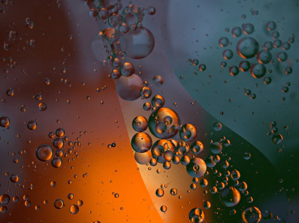 Beautiful abstract bubbles oil in water with black dark orange shiny background ,macro image ,sweet color, blurred droplets - 写真・画像