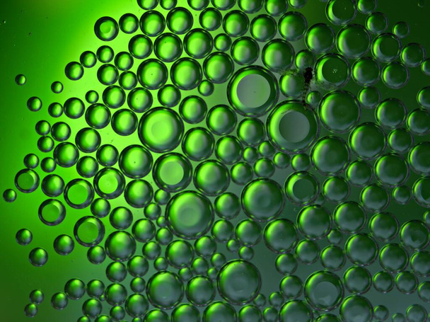 Kaunis abstrakti kuplia öljy vedessä vihreä kiiltävä hämärtynyt tausta, makrokuva, makea väri, pisarat - Valokuva, kuva