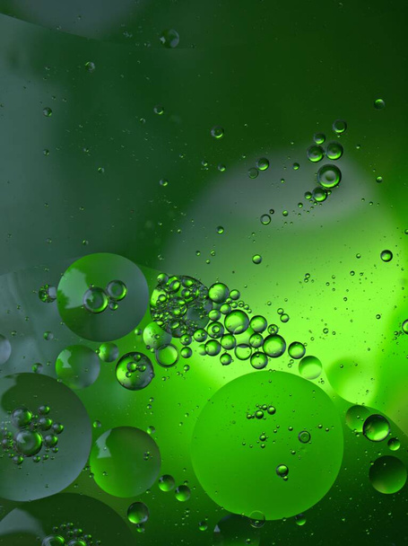 Gyönyörű absztrakt buborékok olaj vízben zöld fényes homályos háttér, makro kép, édes szín, cseppek - Fotó, kép