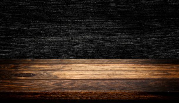 Vista lateral do tampo da mesa de madeira vazio com fundo de textura de parede de madeira escura para exibição de produto
. - Foto, Imagem