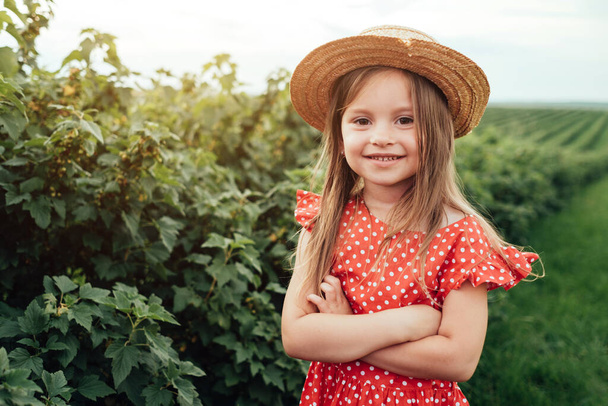 Gyönyörű kislány öltözött piros Polka Dot ruha, szórakozás időt mező városon kívül, gyermekkori koncepció - Fotó, kép