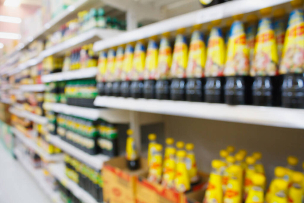 Фон супермаркета размыт с полкой из соусовых бутылок - Фото, изображение