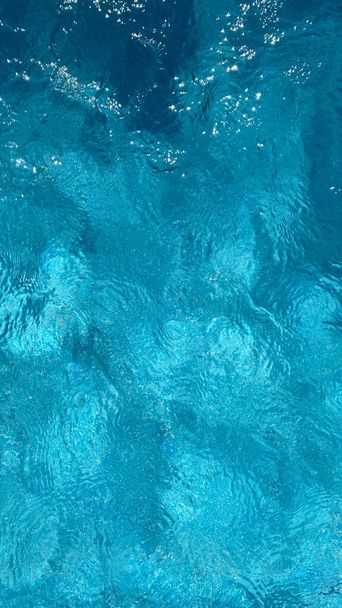 ソフトフォーカスの背景。青い背景に抽象的なスタイルでスイミングプールの水のテクスチャ。リップル水。スイミングプールの水の太陽の反射背景。夏休み. - 写真・画像