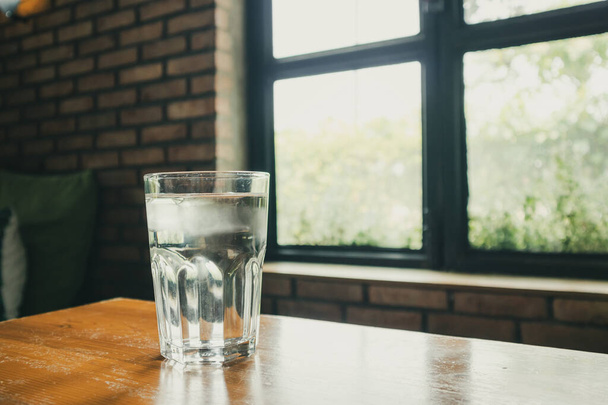 vaso de agua mineral sobre mesa de madera en restaurante - Foto, imagen