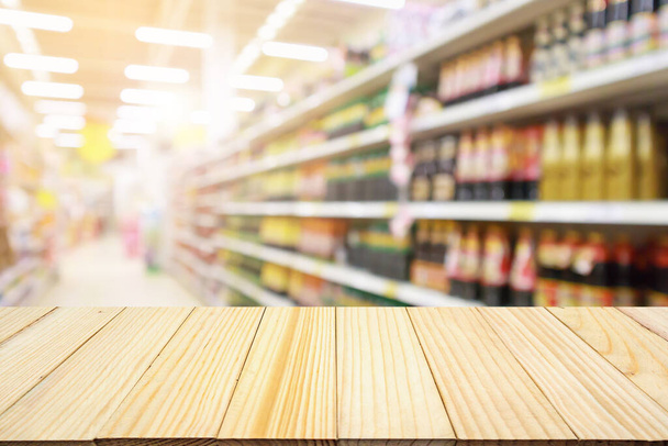 supermercado loja de desconto corredor e prateleiras de produtos interior desfocado abstrato borrão fundo com mesa de madeira
 - Foto, Imagem