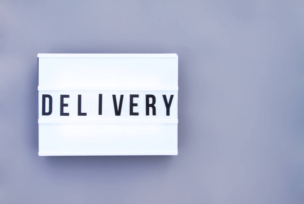 Delivery word on white display on gray background - Photo, Image