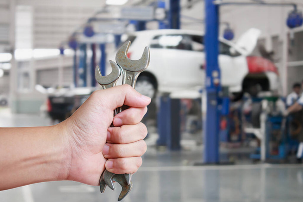 Mão do mecânico profissional do automóvel com chave inglesa, serviço de reparação de automóveis
 - Foto, Imagem