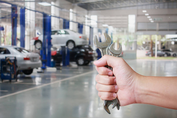 Main de mécanicien automobile professionnel avec clé, service de réparation automobile - Photo, image
