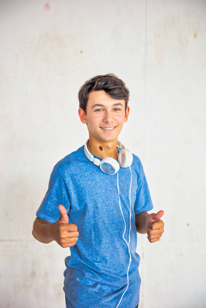 Szczęśliwy biały nastolatek chłopiec gotowy do słuchania muzyki, odizolowany na białym tle. - Zdjęcie, obraz