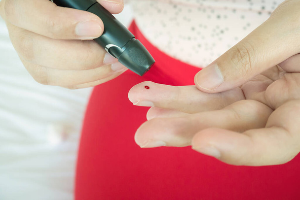женщина с помощью Ланселет на пальце, диабет тест проверки уровня сахара в крови - Фото, изображение