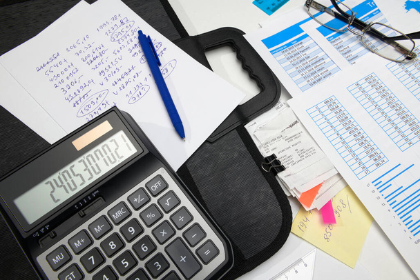 business office desk closeup - financial reports, analysis and accounting, set of documents, tables and graphs, various items for bookkeeping, calculator - Photo, Image