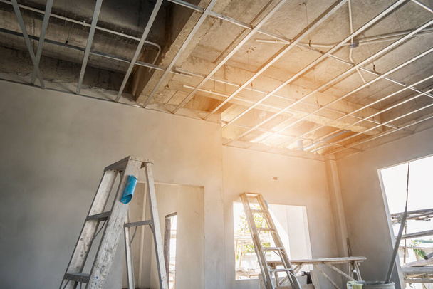 Установка металлической рамы для потолка гипсокартона в строящемся доме - Фото, изображение