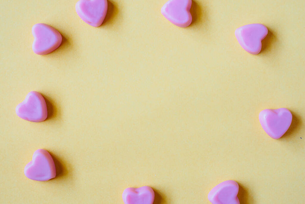 Valentijnsdag achtergrond met hart vorm snoep op gele achtergrond - Foto, afbeelding