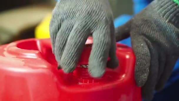 Mann mit Gasmaske überprüft Öl in roter Gallone - Filmmaterial, Video