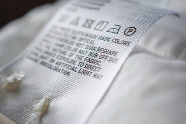 Тканина етикетка з інструкціями по догляду за білизною
 - Фото, зображення