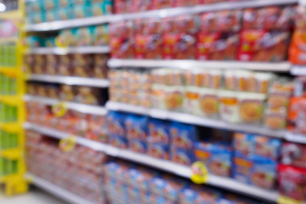 Abstrakti hämärtää supermarket erilaisia pikaruokaa välipaloja sirut tuote hyllyillä varastossa defocused tausta - Valokuva, kuva