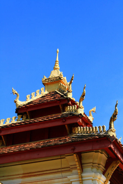 Golden naga on Art Roof of Buddhist temple with blue sky in Wat Pha That Luang Temple Vientiane Province, LAOS  - Фото, зображення