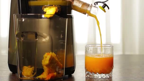 zumo de naranja fresca vierte de exprimidores en un vaso - Imágenes, Vídeo